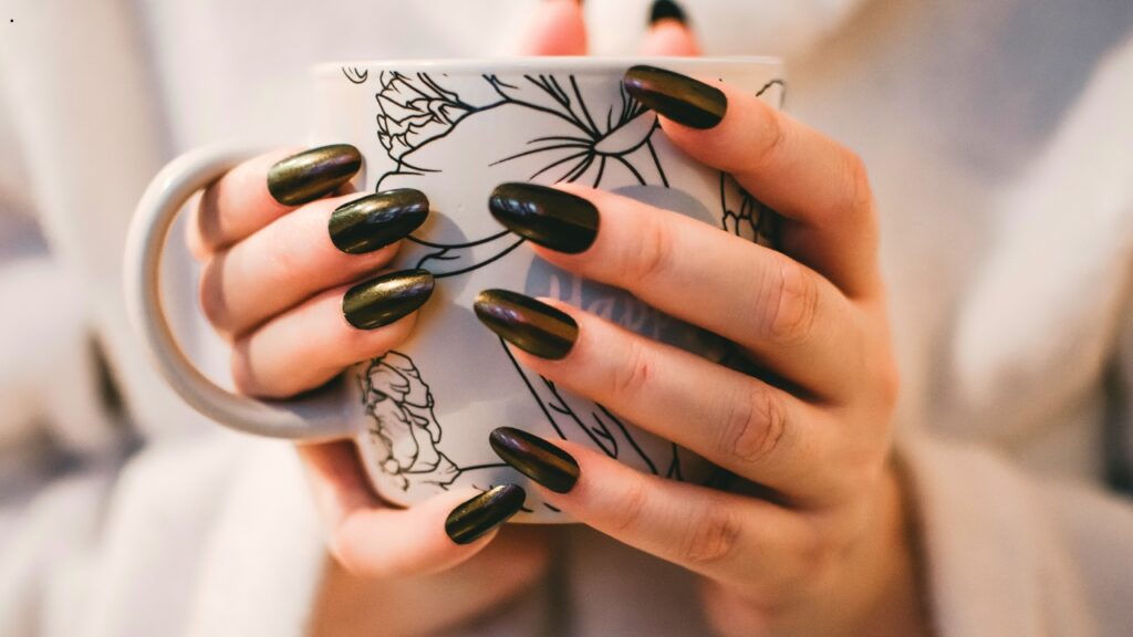 Glossy dark nail extensions demonstrating strength and durability for everyday wear and long-lasting manicure results.